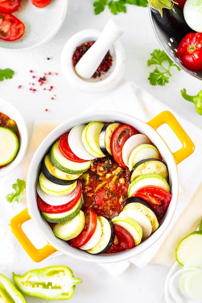 Bereiding van ratatouille een traditionele franse provinciale groenteschotel witte achtergrond bovenaanzicht