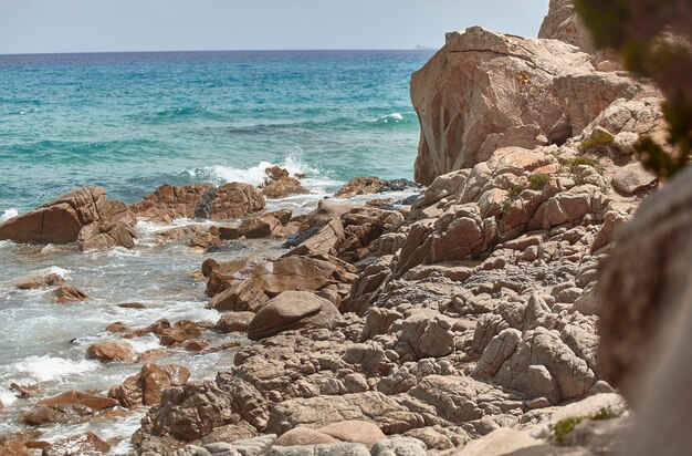 Berg aan zee in het zuiden van Sardinië, gefilterd door een klif in de zomer met zeegolven