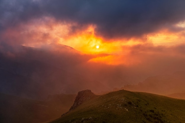 Berg dramatische zonsondergang in wolken