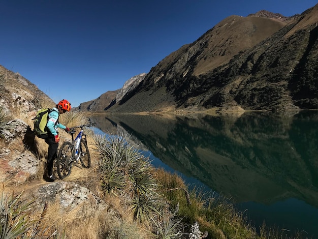 Berg in de Andes boven een lagune en mensen die fietsen