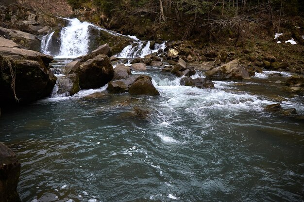 Berg rivier smalle rotsen en cascades vormen Landelijk gebied van Oekraïens dorp in de bergen Vroege lente in de Karpaten