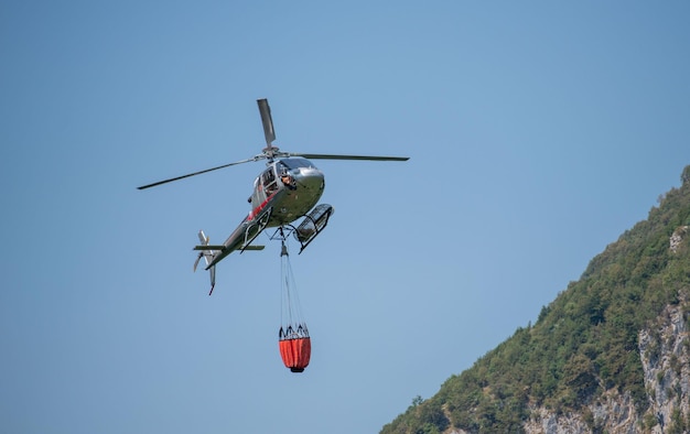 ベルガモイタリア2022年7月火を消すために水を輸送するために使用されるヘリコプター