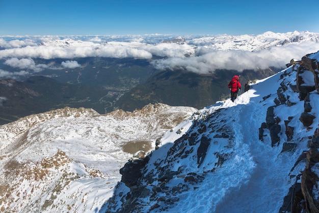 Bergbeklimmen oplopend naar de top boven de wolken in de Franse Alpen