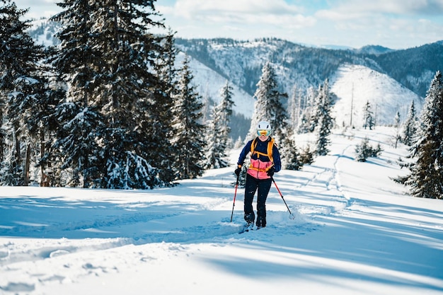 Bergbeklimmer backcountry ski wandelen ski vrouw alpinist in de bergen Skitochten in alpine landschap met besneeuwde bomen Avontuurlijke wintersport Freeride skiën