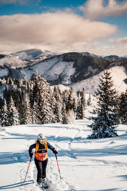 Bergbeklimmer backcountry ski wandelen ski vrouw alpinist in de bergen Skitochten in alpine landschap met besneeuwde bomen Avontuurlijke wintersport Freeride skiën