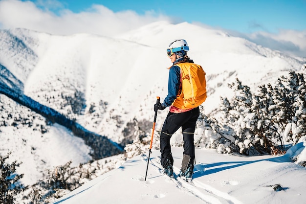 Bergbeklimmer backcountry ski wandelen ski vrouw alpinist in de bergen Skitochten in alpine landschap met besneeuwde bomen Avontuurlijke wintersport Freeride skiën