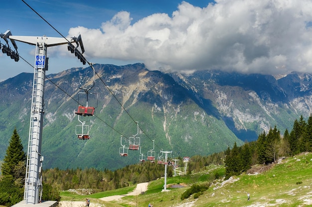 Berghut, huis op heuvel. Alpenweidelandschap. Kabelbaan. Groot weilandplateau. Slovenië