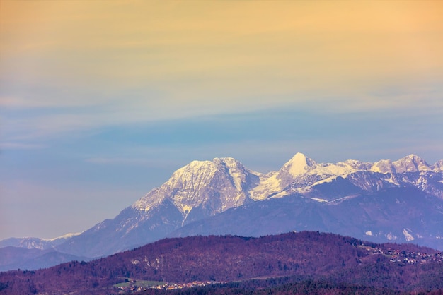 Bergketen bedekt met sneeuw tegen een gradiënt avondrood