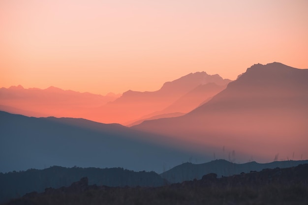 Bergketen in roze zonlicht bij zonsondergang. Blauwe bergen met de roze lucht. Prachtige herfst landschap, natuur achtergrond. Noord-Kaukasus, Rusland.