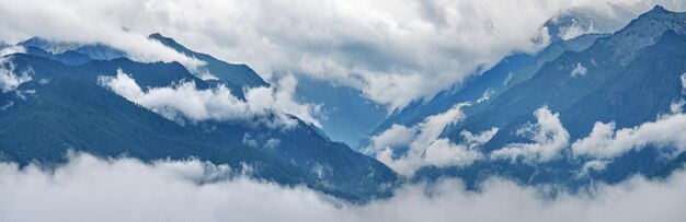 Bergkloof en toppen in de wolken panoramisch uitzicht