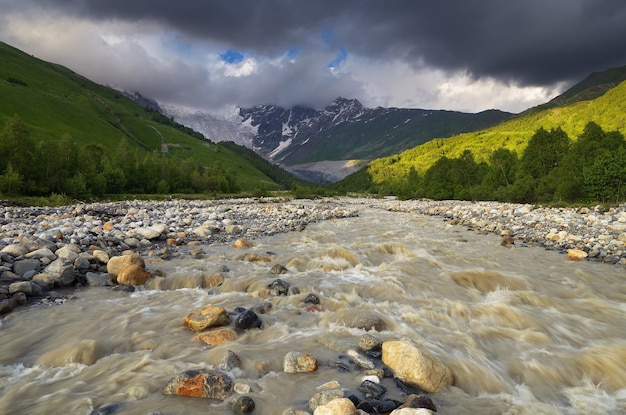 Berglandschap met een rivier. Zonnige zomerdag met wolken. Belangrijkste Kaukasische bergkam. Zemo Svaneti, Georgië