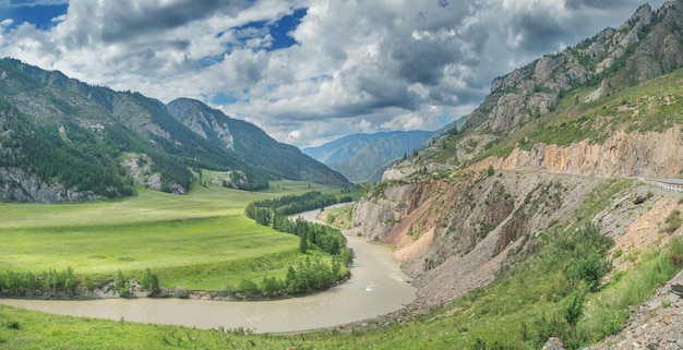 Berglandschap met rivier en weg bewolkt weer