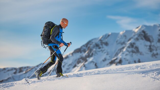 Bergop met ski's en zeehondenhuiden op de Alpen