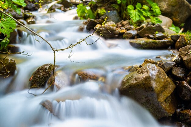 Bergrivier met kleine waterval met helder turkoois water dat naar beneden valt