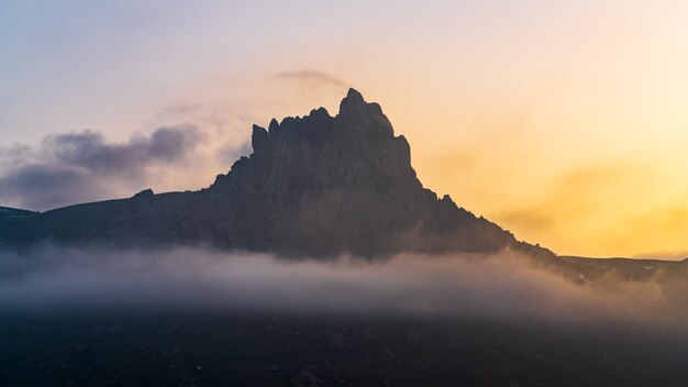 Bergtop in de mist bij zonsondergang
