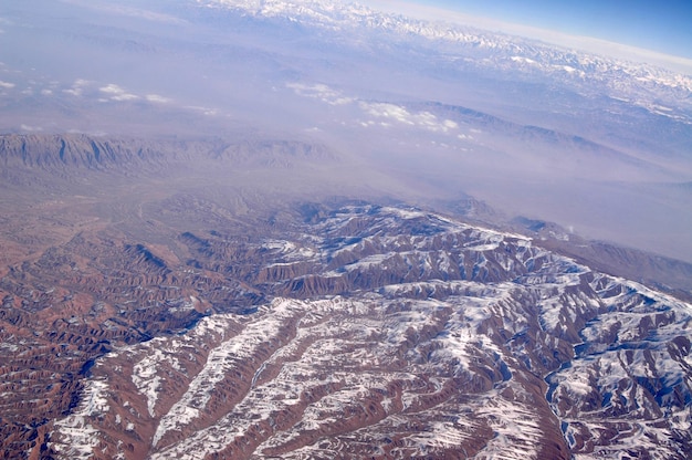 Bergtoppen met besneeuwde, luchtfoto. Aardoppervlak. Milieubescherming en ecologie. Ontdekking en avontuur. Behandel de aarde zoals jij wilt dat de aarde jou behandelt.