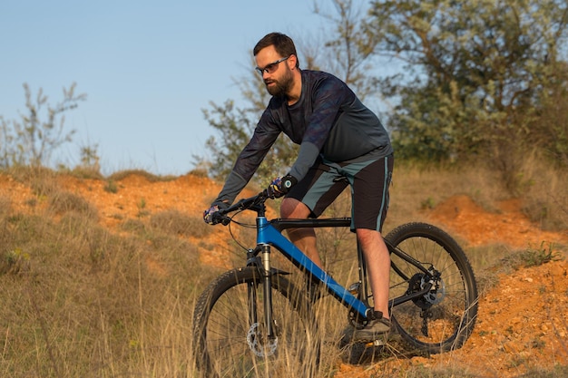 Bergtoppen veroveren door fietser in korte broek en jersey op een moderne carbon hardtail bike