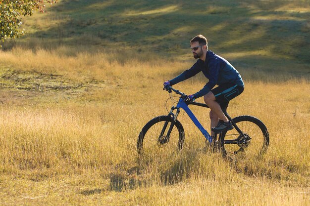 Bergtoppen veroveren door fietser in korte broek en jersey op een moderne carbon hardtail bike