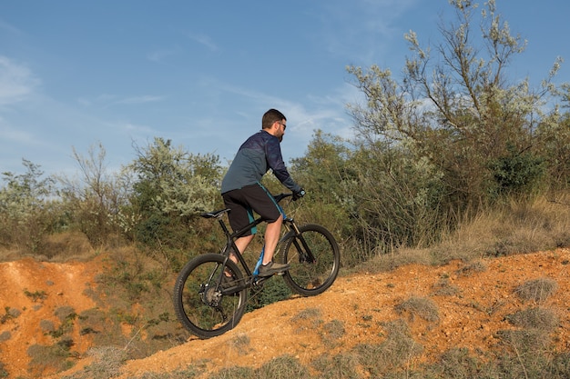 Bergtoppen veroveren door fietser in korte broek en jersey op een moderne carbon hardtail bike