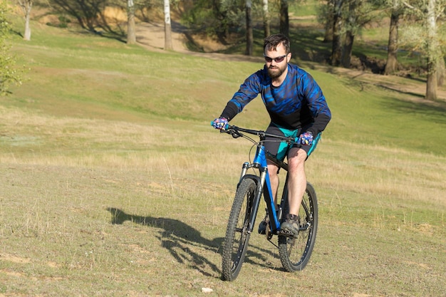 Bergtoppen veroveren door fietser in korte broek en jersey op een moderne carbon hardtail fiets met luchtgeveerde voorvork