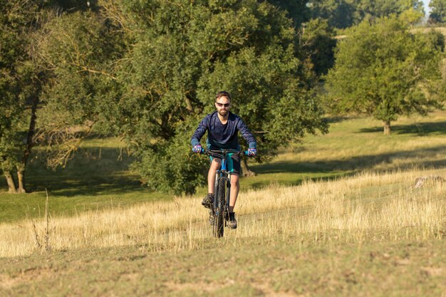 Bergtoppen veroveren door fietser in korte broek en jersey op een moderne carbon hardtail fiets met luchtgeveerde voorvork