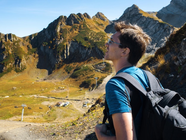 Bergtoppen veroveren een jonge man maakt een reis met een rugzak in de bergen een reiziger in een ...