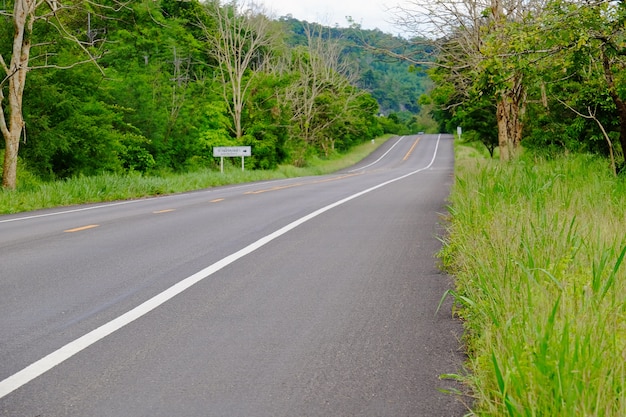 Bergweg met bomen. De schilderachtige route heeft groene bomen en lucht. Reis naar Thailand.