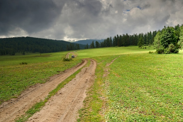 Bergweg wazig door regen. off-road in de bergen. Sombere bewolkte hemel en regen in de bergen. Altai