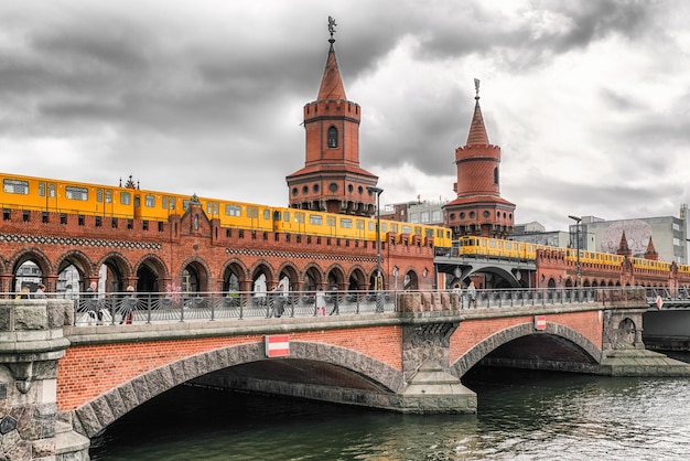 Photo berlin germany april 8 2017 yellow train on oberbaum bridge over river spree in city berlin