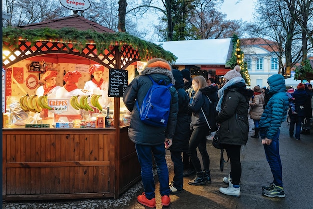 Berlino, germania - 9 dicembre 2017: persone sul mercatino di natale al palazzo di charlottenburg in inverno a berlino in germania. decorazione della fiera dell'avvento e bancarelle con oggetti di artigianato sul bazaar.