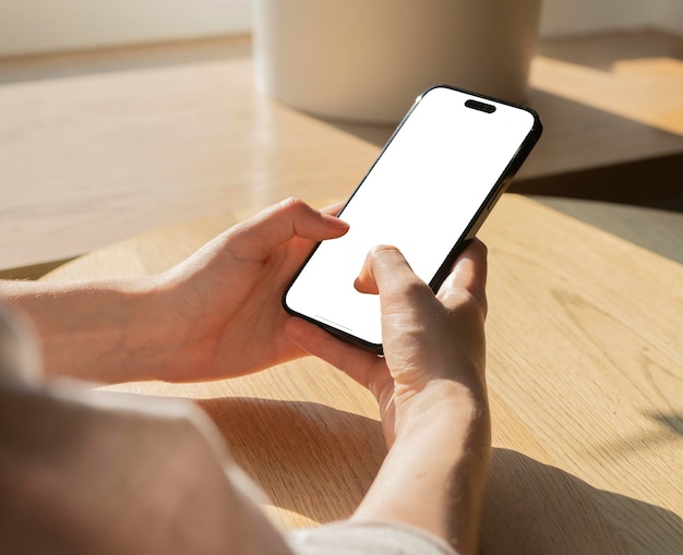 ドイツ ベルリン 2023年10月20日 手で携帯電話のモックアップを握って指でテキストメッセージを送る