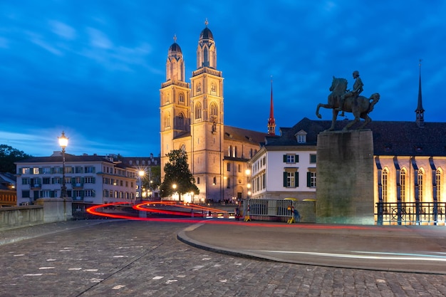 Beroemde Grossmunster-kerk langs de rivier de Limmat 's nachts in de oude binnenstad van Zürich, de grootste stad van Zwitserland