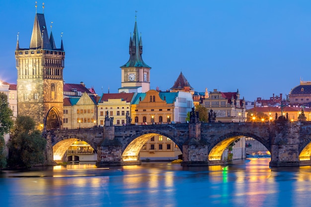 Beroemde Praagse bezienswaardigheden torens en brug 's nachts met verlichte stad Praag, Tsjechië Europa