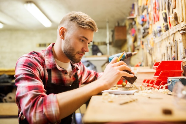 Beroep, timmerwerk, houtbewerking en mensenconcept - timmerman die met houten plank op workshop werken