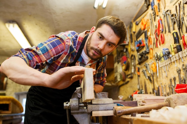 beroep, timmerwerk, houtbewerking en mensenconcept - timmerman die met vliegtuig en houten plank op workshop werkt