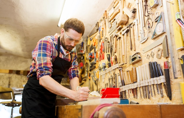 beroep, timmerwerk, houtbewerking en mensenconcept - timmerman die met vliegtuig en houten plank op workshop werkt