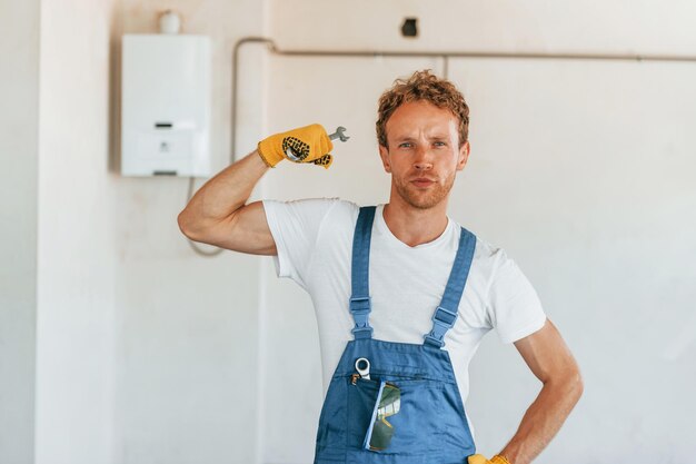 Beroepsberoep Jonge man aan het werk in uniform bij de bouw overdag