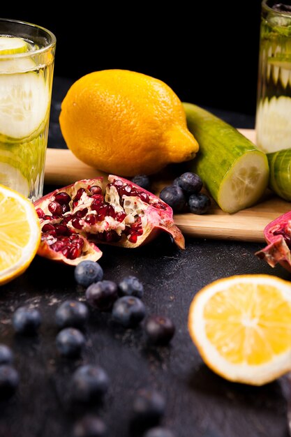 Berried, pomegranate and lemons on dark vintage wooden background