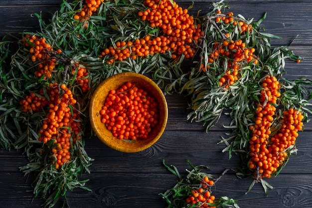 Berries and branches of sea buckthorn on dark wooden