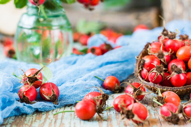 Berries of a dog rose in a bowl on a wooden table