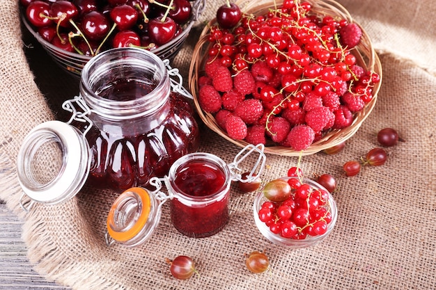 Berries jam in glass jar on table, close-up