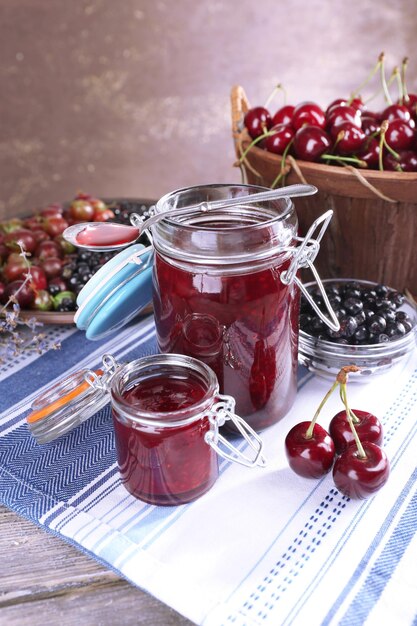 Berries jam in glass jar on table closeup