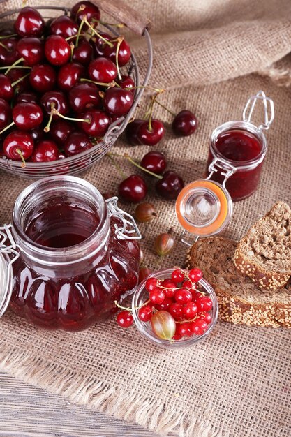 Berries jam in glass jar on table closeup