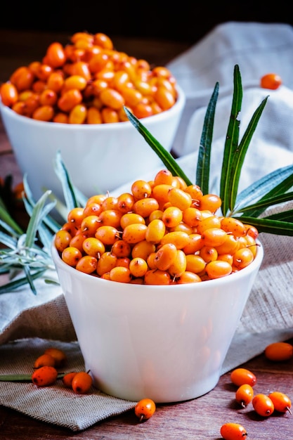 Berries of sea buckthorn dark wood background selective focus