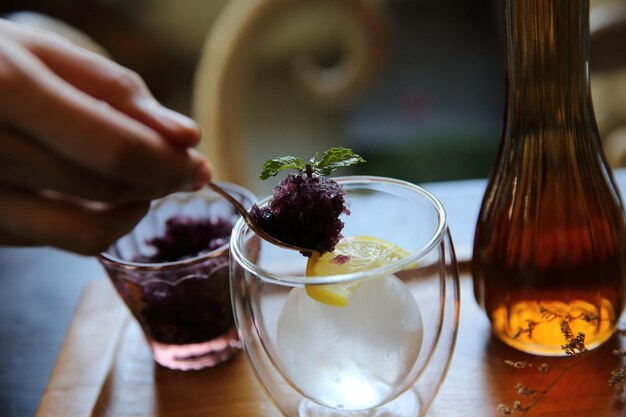 Berries tea with ice ball on wood background