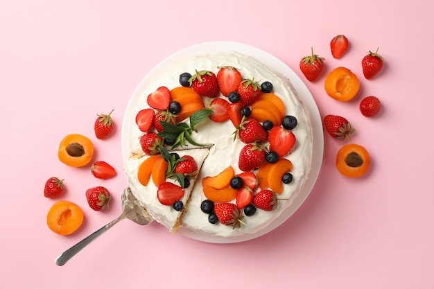 Berry cream cake on pink background, top view. Delicious dessert