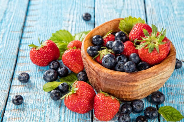 Berry fruit in saucer placed on old wooden planks