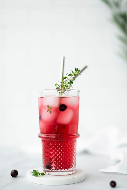 Berry juice from blackcurrant and cranberries with ice in a glass