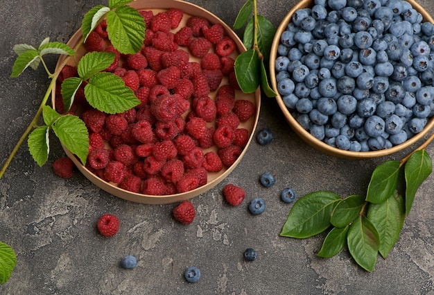 Berry mix A variety of summer berries raspberries blueberries in cups on a wooden table