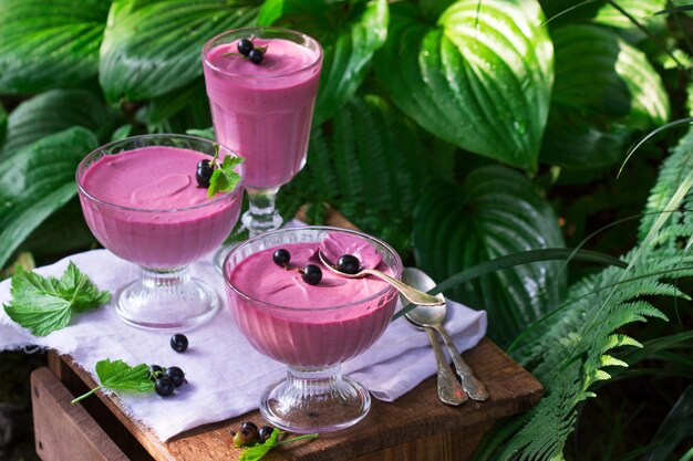 Berry mousse in glass vases on a wooden in the garden.